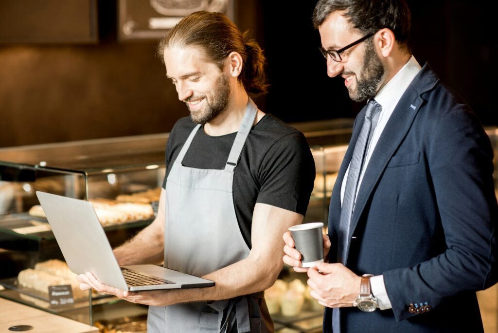 Businessman and barista working in the pastry shop