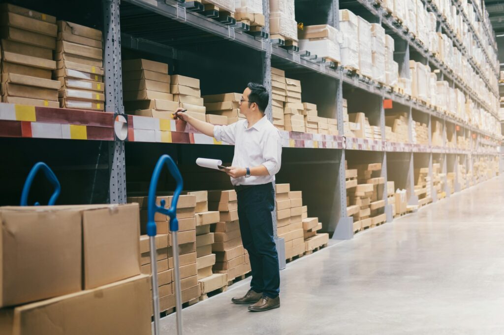 Man warehouse worker checking goods at warehouse.